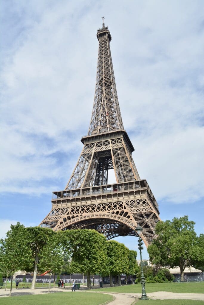 Eiffel Tower in Paris among blue skies and green trees.